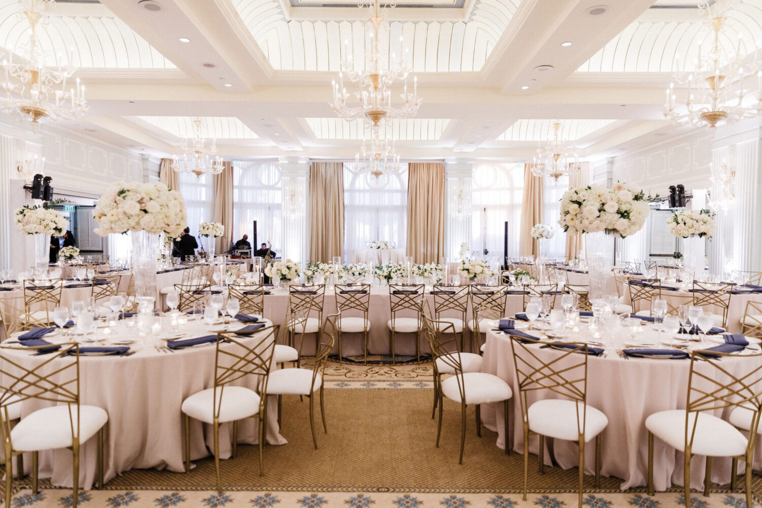 Wedding reception in the Colonnade Ballroom, with tables decorated with white floral centerpieces.