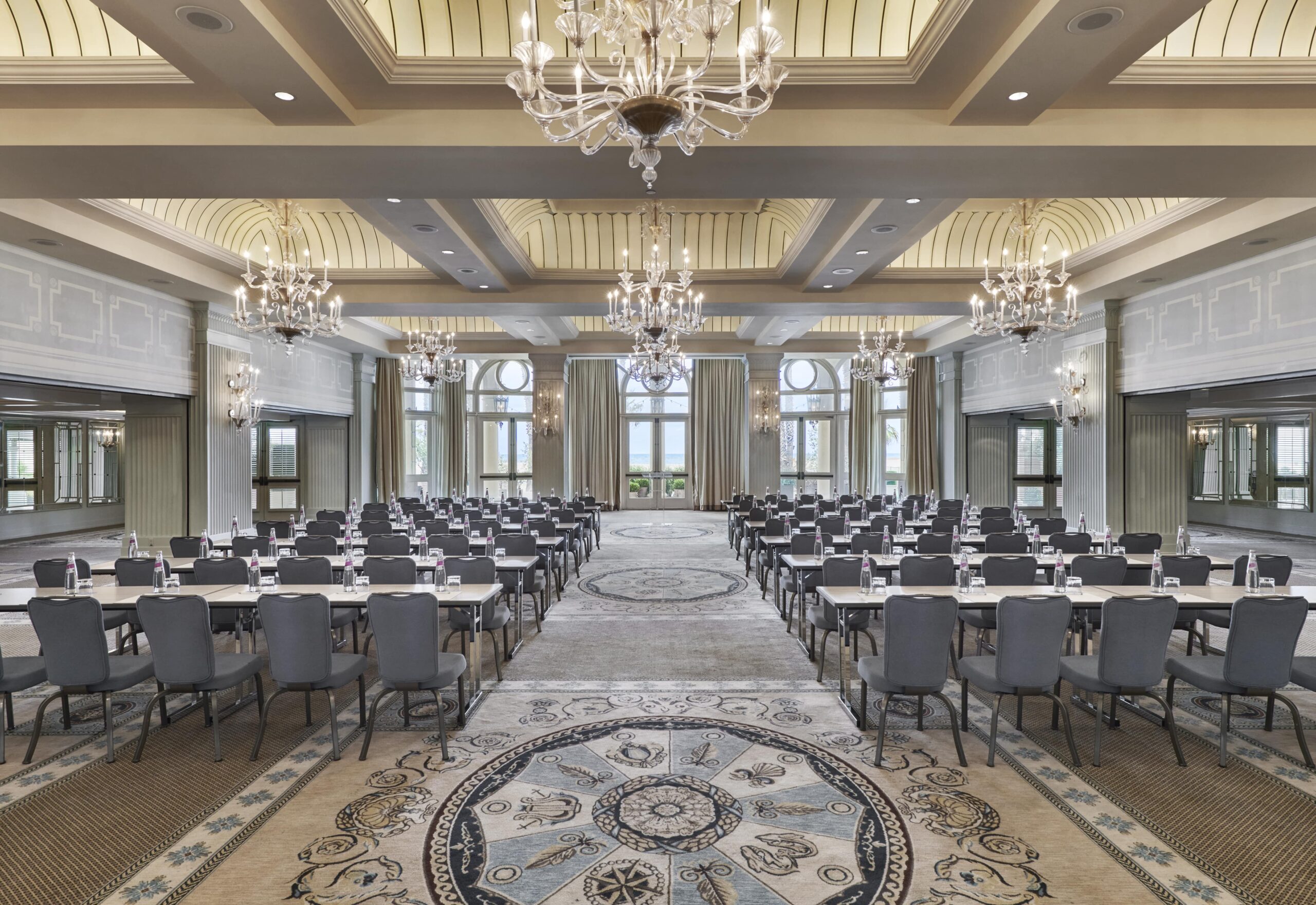 Colonnade Ballroom with several chandeliers, rows of tables and chairs set up for a meeting