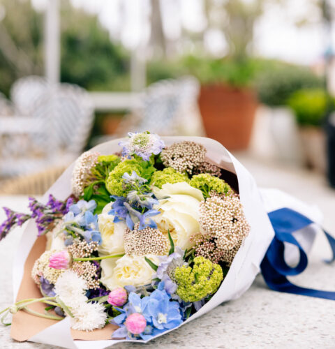 up close shot of a bouquet of flowers tied together with a navy blue ribbon