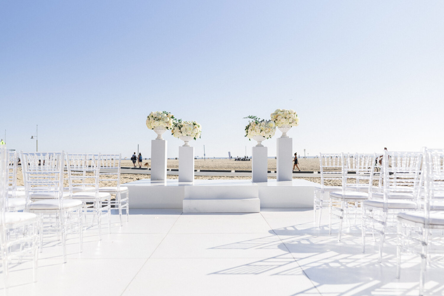 wedding ceremoney set up with 4 marble posts with white flower arranges on top