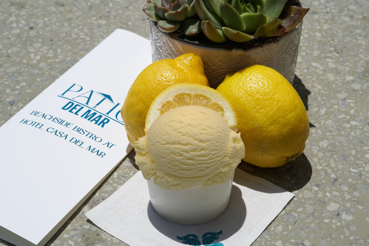 scoop of lemon ice cream with lemons next to the cup