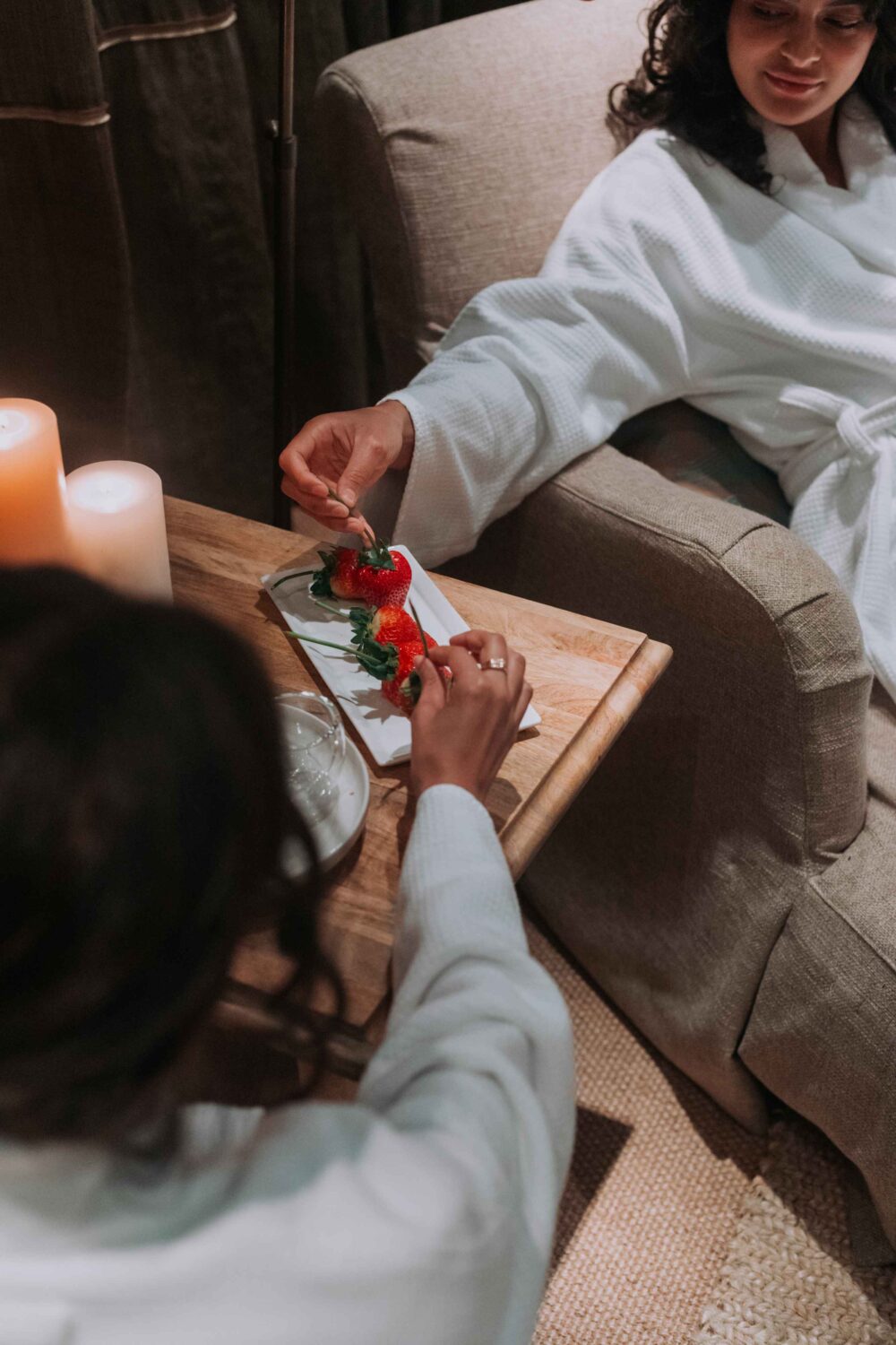 two women in the spa seating area eating strawberries