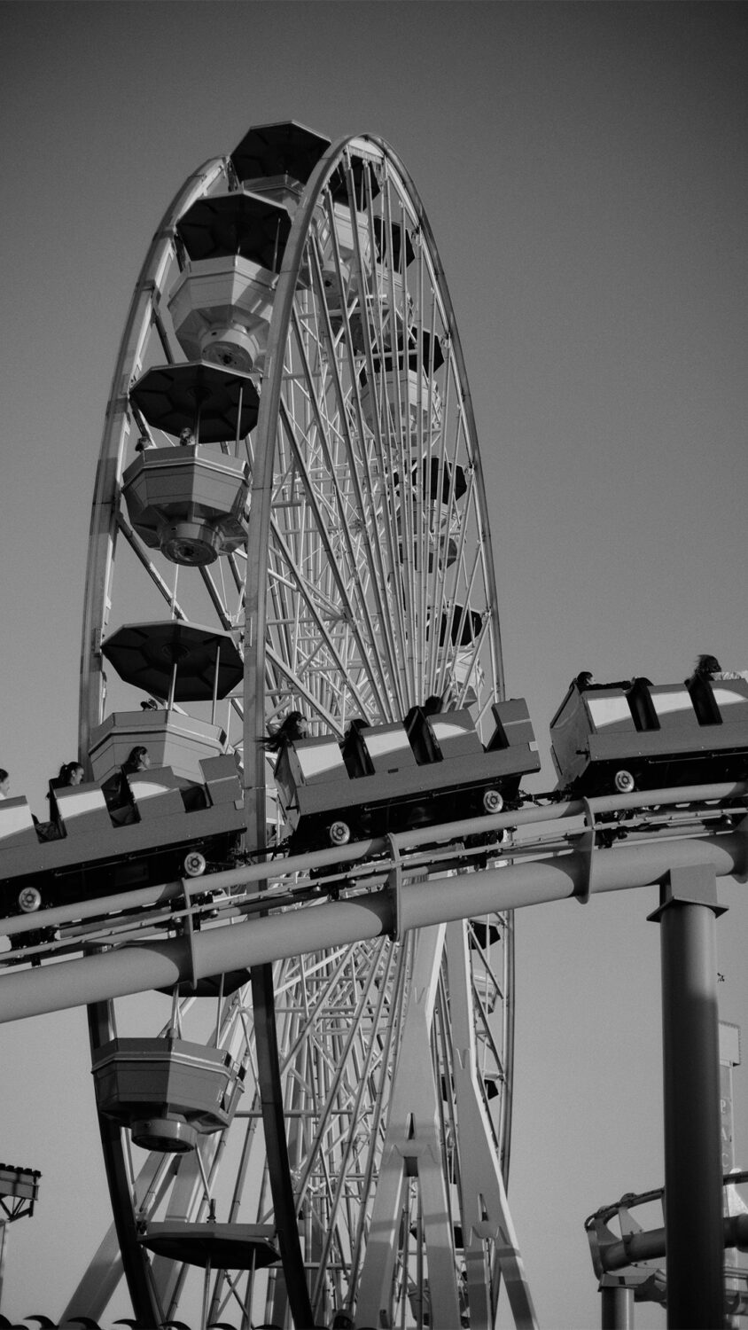 b&w image:va close up shot of the Santa Monica Pier Farris Wheel and roller coaster